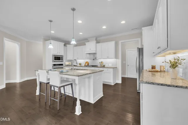 a view of an empty room and chandelier fan