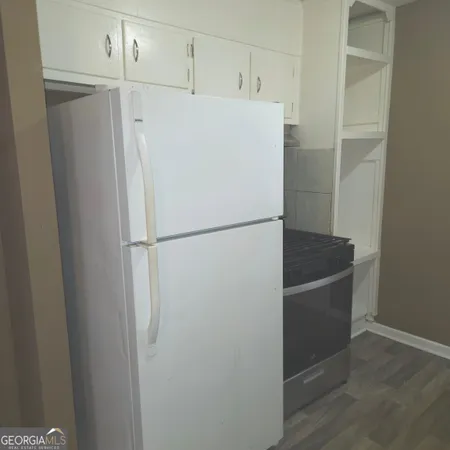 a white refrigerator freezer and a stove sitting inside of a kitchen