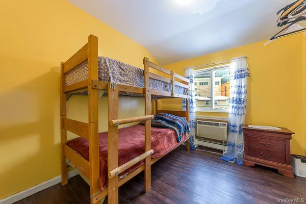 a bedroom with bed and wooden floor