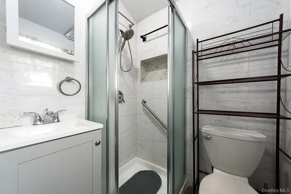 a bathroom with a shower sink vanity mirror and toilet