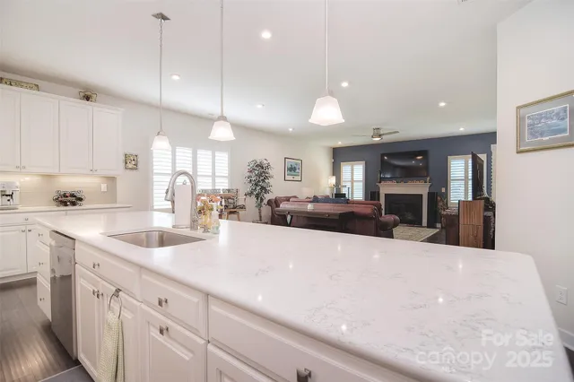 a large kitchen with kitchen island a large counter top stainless steel appliances and cabinets