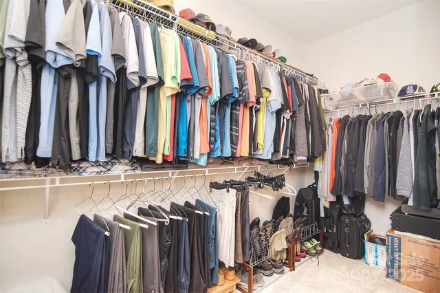 a view of walk in closet with clothes