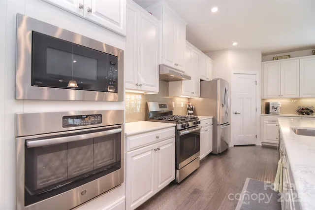 a kitchen with stainless steel appliances kitchen island granite countertop a stove a sink and a microwave