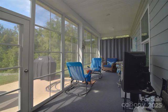 a living room with furniture a flat screen tv and a window