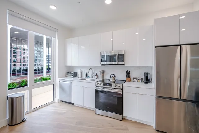 a kitchen with white cabinets and white appliances