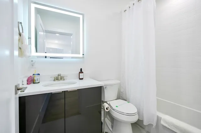 a bathroom with a toilet sink vanity and mirror