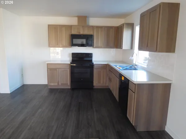 a kitchen with a sink cabinets and wooden floor