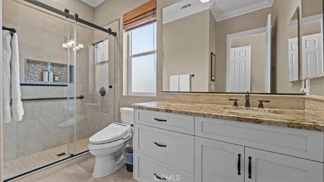 a bathroom with a granite countertop sink a toilet and shower