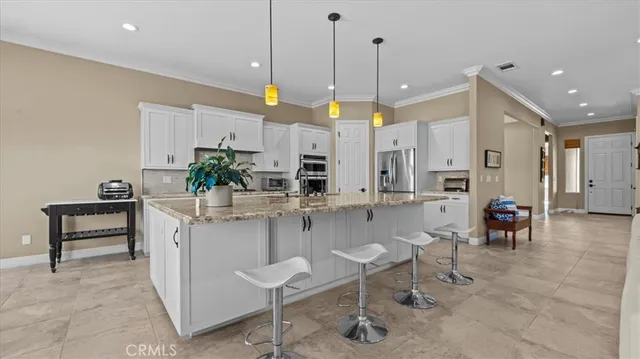 a kitchen with kitchen island granite countertop a table and chairs in it