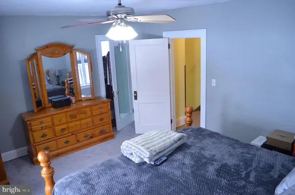 a bedroom with a bed and a mirror on dresser