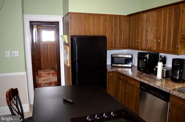 a kitchen with granite countertop stainless steel appliances a refrigerator and cabinets