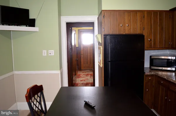 a view of a kitchen with a refrigerator a microwave and furniture