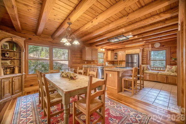 a dining room with furniture wooden floor a rug and a painting