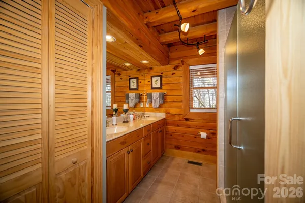 a bathroom with a double vanity sink a toilet and shower