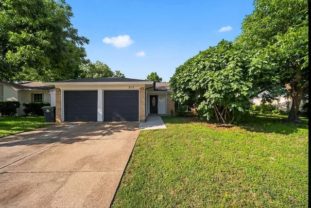 a view of a backyard with a garden and tree