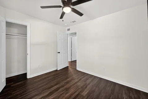a view of an empty room with wooden floor