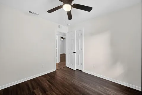 a view of an empty room with wooden floor