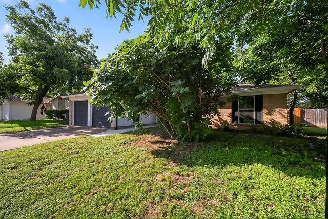a view of a house with backyard and a tree
