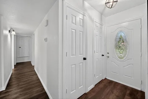 a view of a hallway with wooden floor