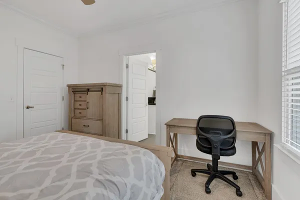 a bedroom with a chair and a window