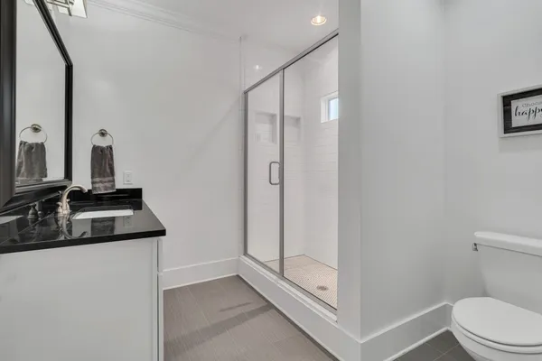a bathroom with a sink a toilet and a mirror
