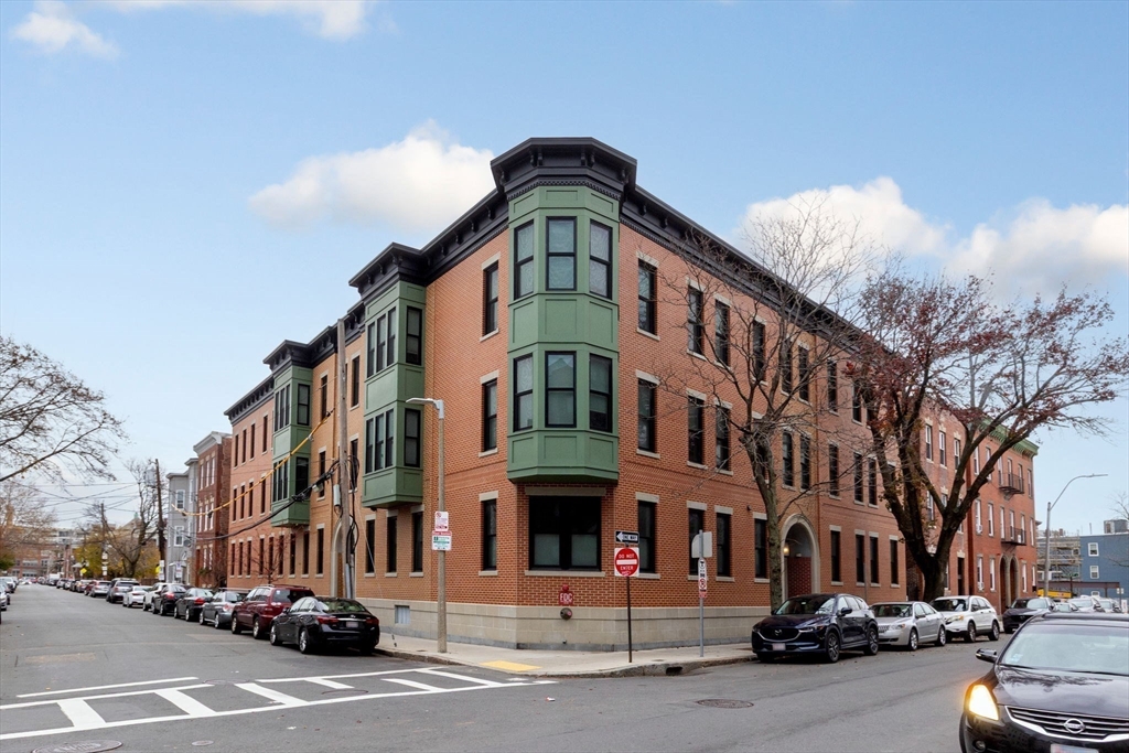 202 Maverick Street, Unit 301 Boston, MA 02128 - Photo 1 of 28 a front view of a building with lot of cars and trees