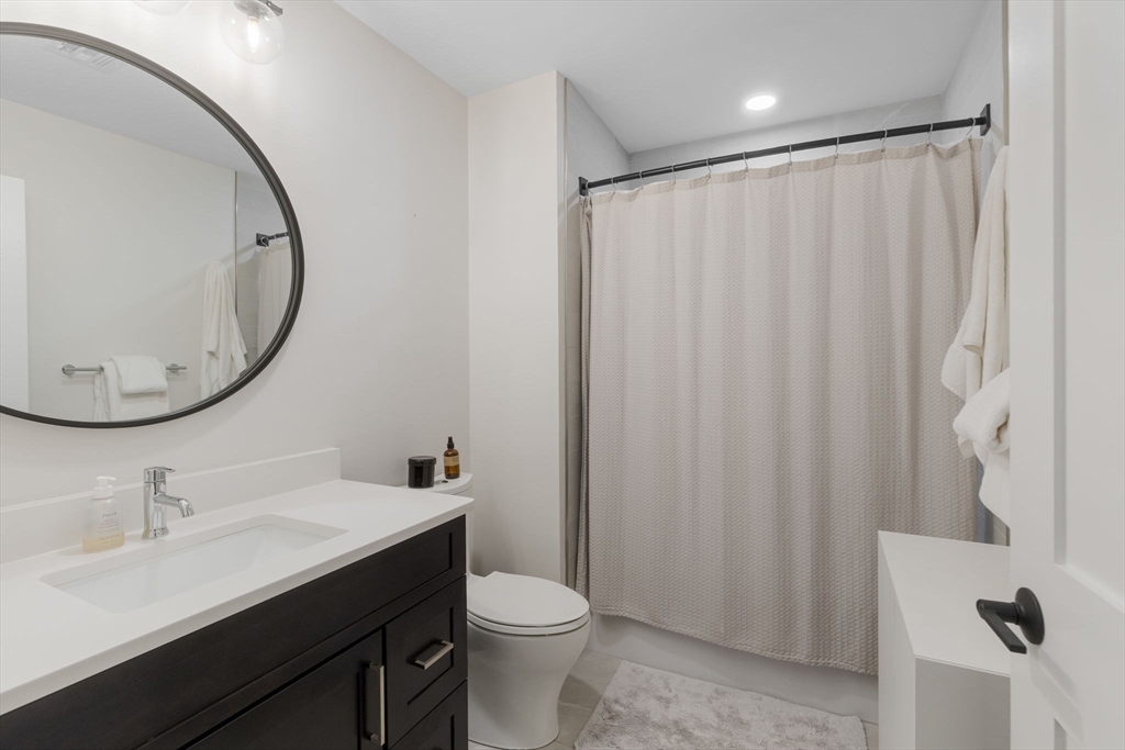 202 Maverick Street, Unit 301 Boston, MA 02128 - Photo 13 of 28 a bathroom with a sink a toilet and a mirror