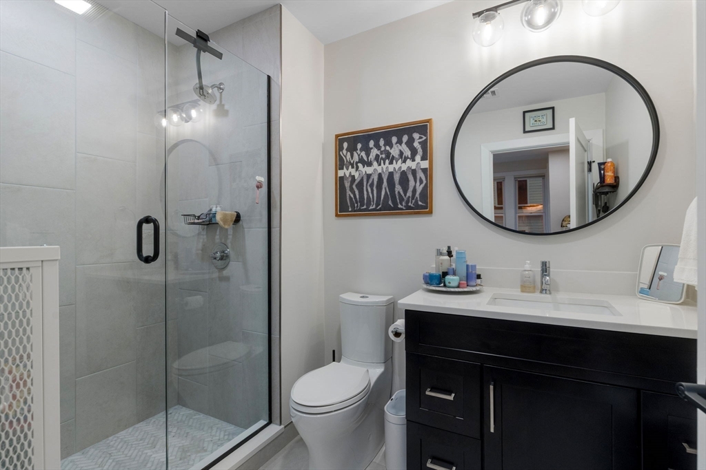 202 Maverick Street, Unit 301 Boston, MA 02128 - Photo 19 of 28 a bathroom with a toilet a sink and a mirror