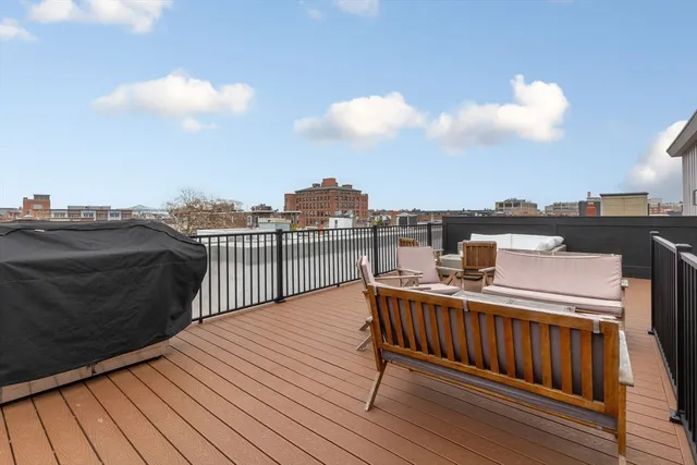 a view of a roof deck with table and chairs