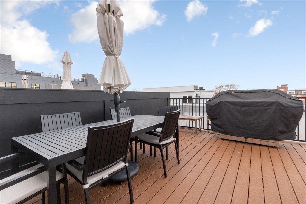 202 Maverick Street, Unit 301 Boston, MA 02128 - Photo 22 of 28 a view of a roof deck with table and chairs