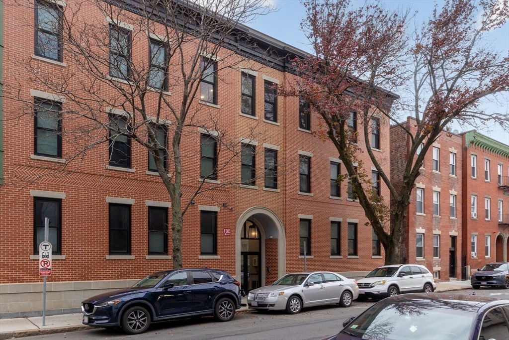 202 Maverick Street, Unit 301 Boston, MA 02128 - Photo 28 of 28 a front view of a residential apartment building with cars parked