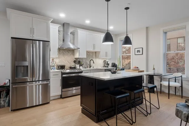 a kitchen with stainless steel appliances a sink a stove and cabinets