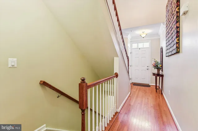 a view of a hallway with wooden floor and staircase