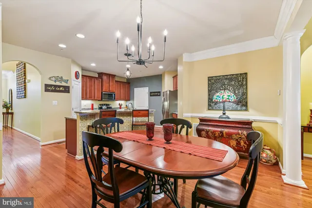 a view of a dining room with furniture a chandelier and wooden floor