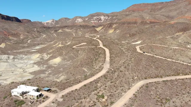 a view of a dry yard with mountains in the background