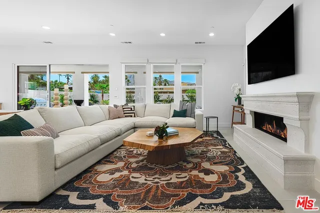 a living room with furniture a flat screen tv and a fireplace