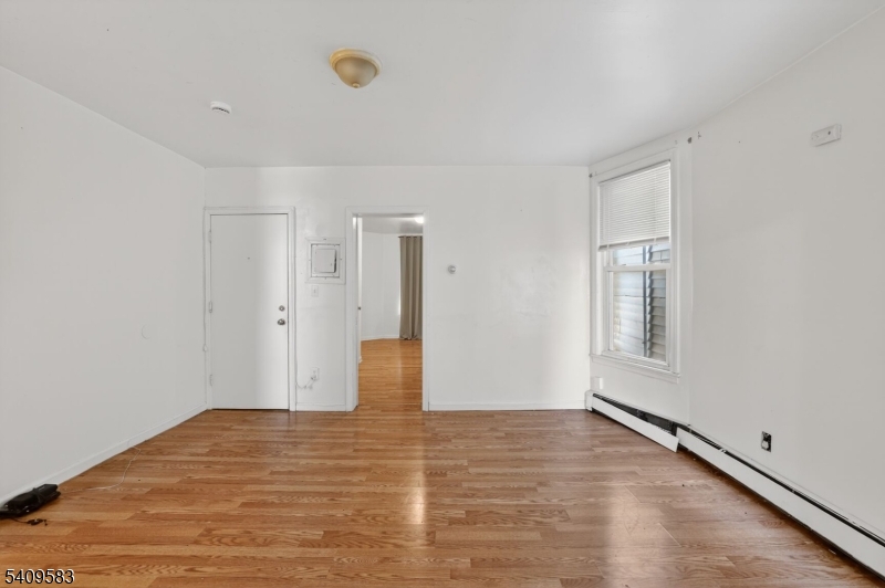 186 3rd Street, Unit 1 Newark, NJ 07107 - Photo 12 of 25 a view of an empty room with wooden floor and a window