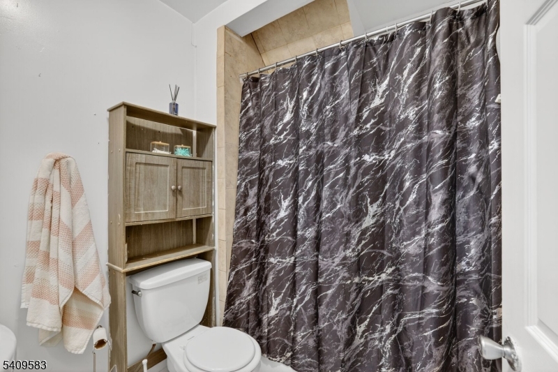 186 3rd Street, Unit 1 Newark, NJ 07107 - Photo 17 of 25 a toilet sitting next to a shower curtain