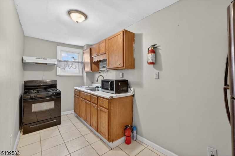 186 3rd Street, Unit 1 Newark, NJ 07107 - Photo 3 of 25 a kitchen with granite countertop a stove top oven and cabinets