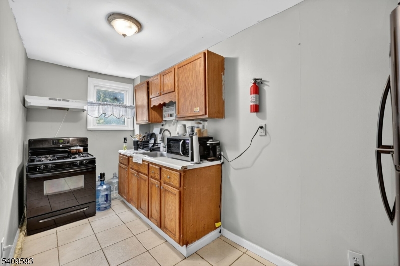 186 3rd Street, Unit 1 Newark, NJ 07107 - Photo 4 of 25 a kitchen with stainless steel appliances granite countertop a stove and a refrigerator