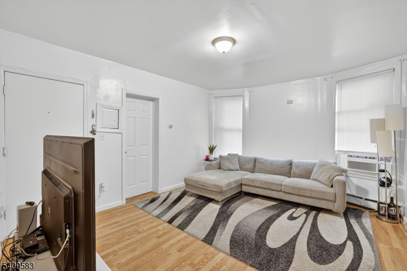 186 3rd Street, Unit 1 Newark, NJ 07107 - Photo 5 of 25 a living room with furniture and a flat screen tv