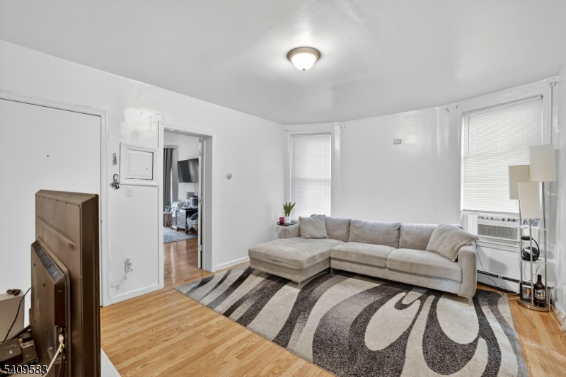 186 3rd Street, Unit 1 Newark, NJ 07107 - Photo 7 of 25 a living room with furniture and a flat screen tv