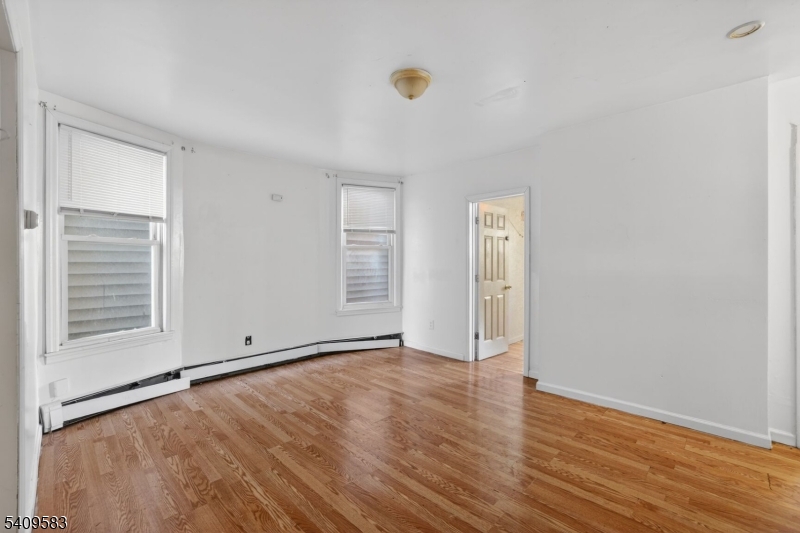 186 3rd Street, Unit 1 Newark, NJ 07107 - Photo 10 of 25 an empty room with wooden floor and windows