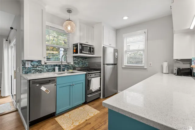 a kitchen with stainless steel appliances granite countertop a sink stove microwave and refrigerator