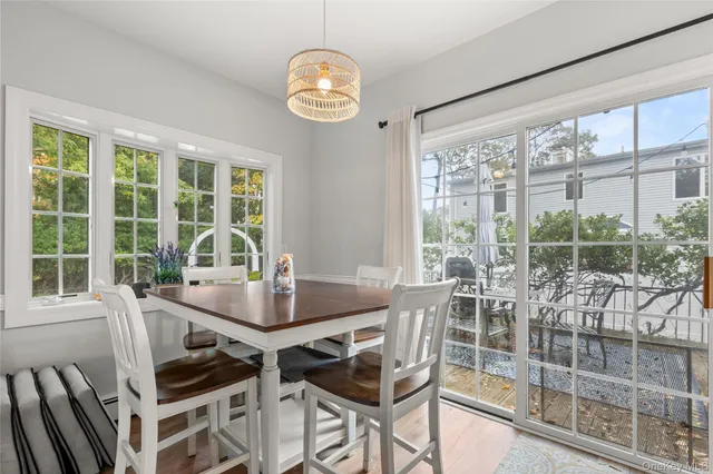 a view of a dining room with furniture large windows and wooden floor