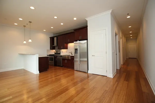 a kitchen with stainless steel appliances a refrigerator and wooden floor