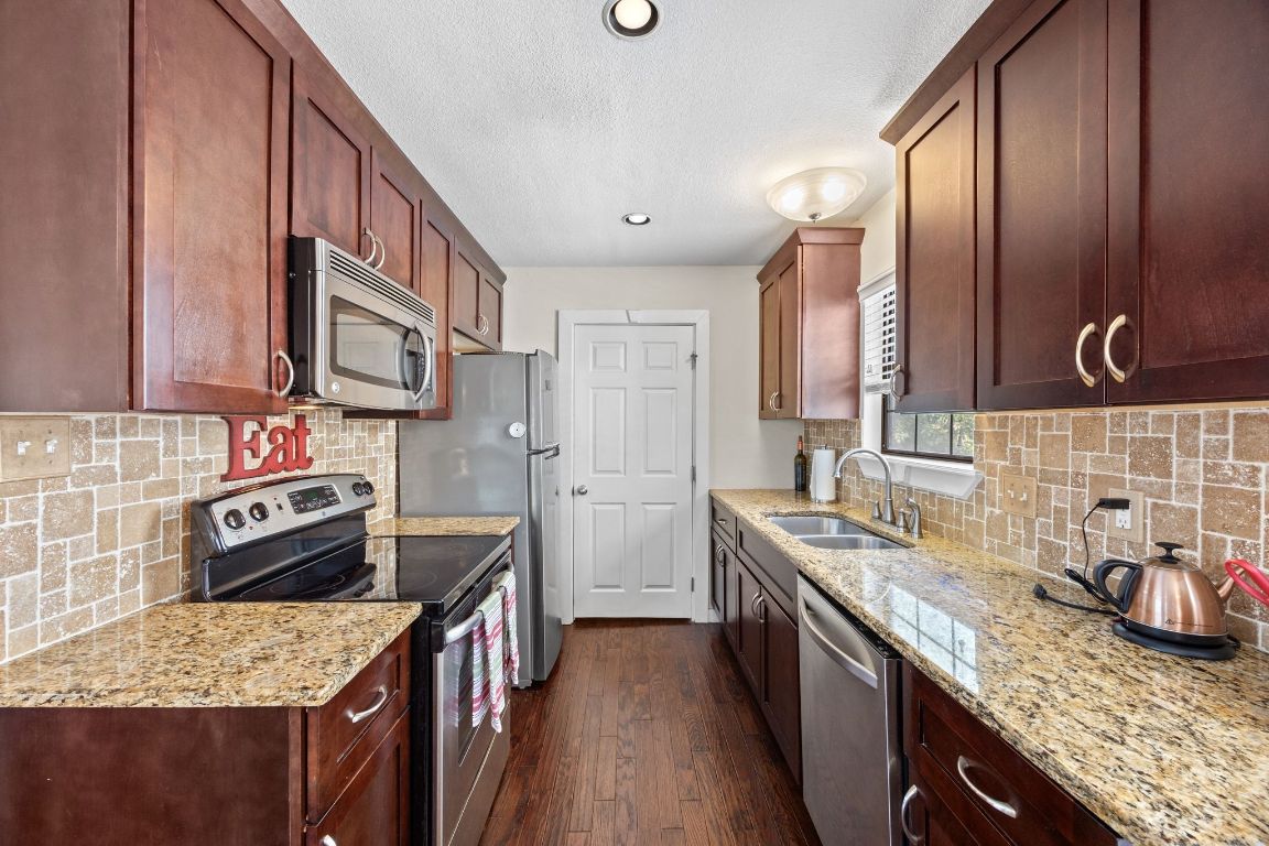 5500 Evans Avenue Austin, TX 78751 - Photo 15 of 27 a kitchen with stainless steel appliances granite countertop a sink stove and cabinets