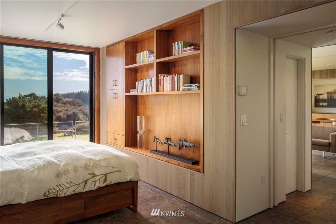 209 Hodgson Road Lopez Island, WA 98261 - Photo 9 of 20 a bed sitting in a bedroom next to a large window with a hallway