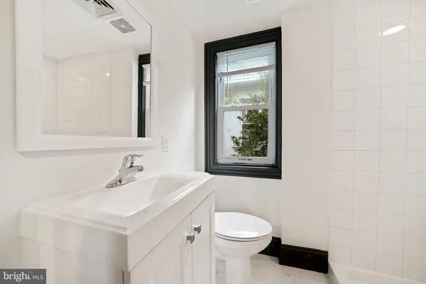 a bathroom with a sink a toilet and mirror