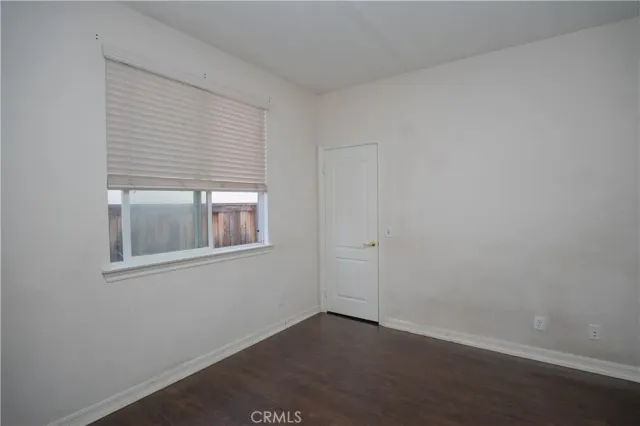 a view of an empty room with glass door and chandelier